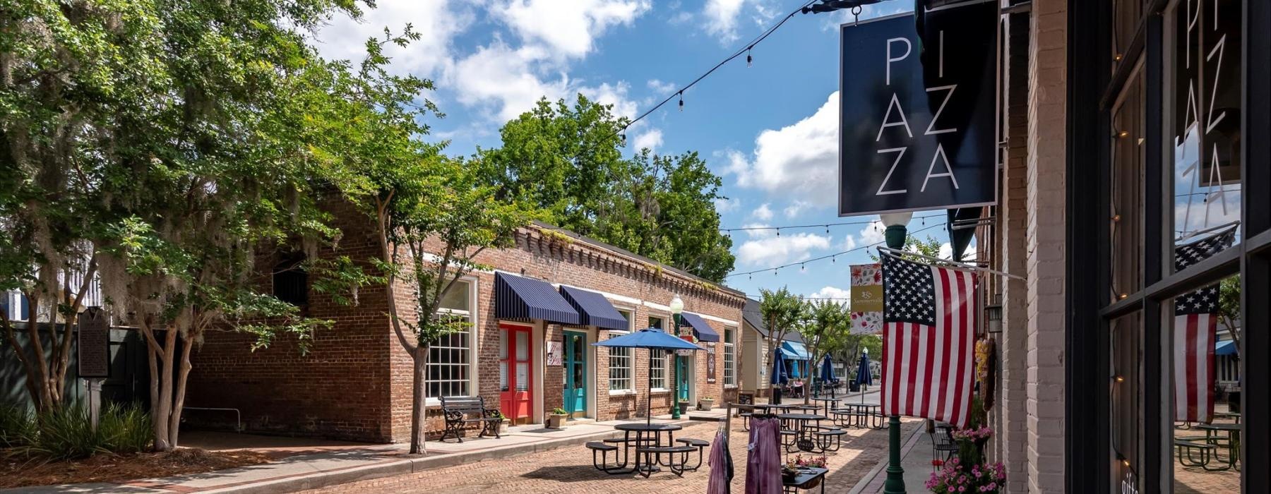 a brick road with tables and chairs on it